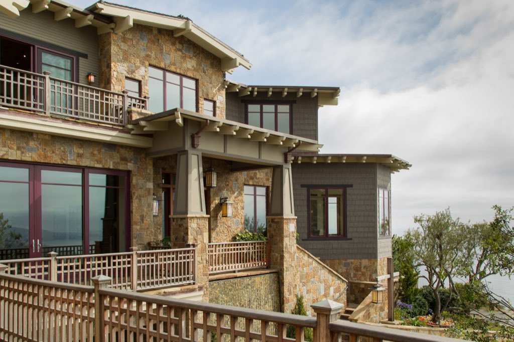 Laguna Beach hillside estate: stone and shingle façade with craftsman balconies