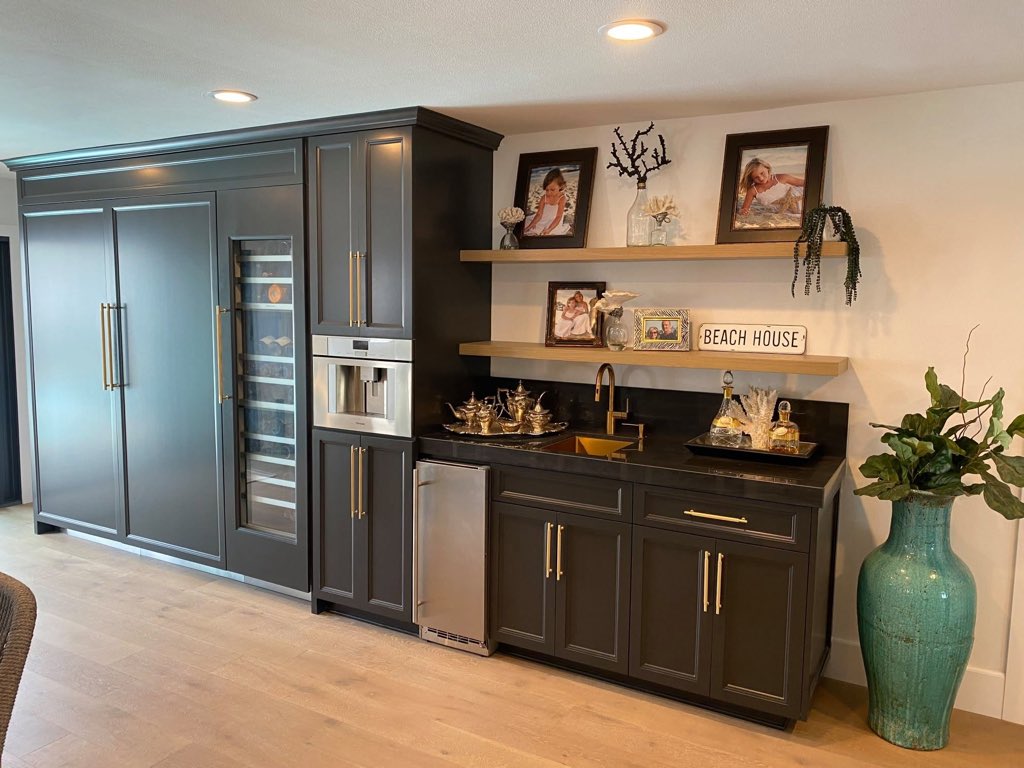 Charcoal painted bar with brass pulls, wine column and floating oak shelves